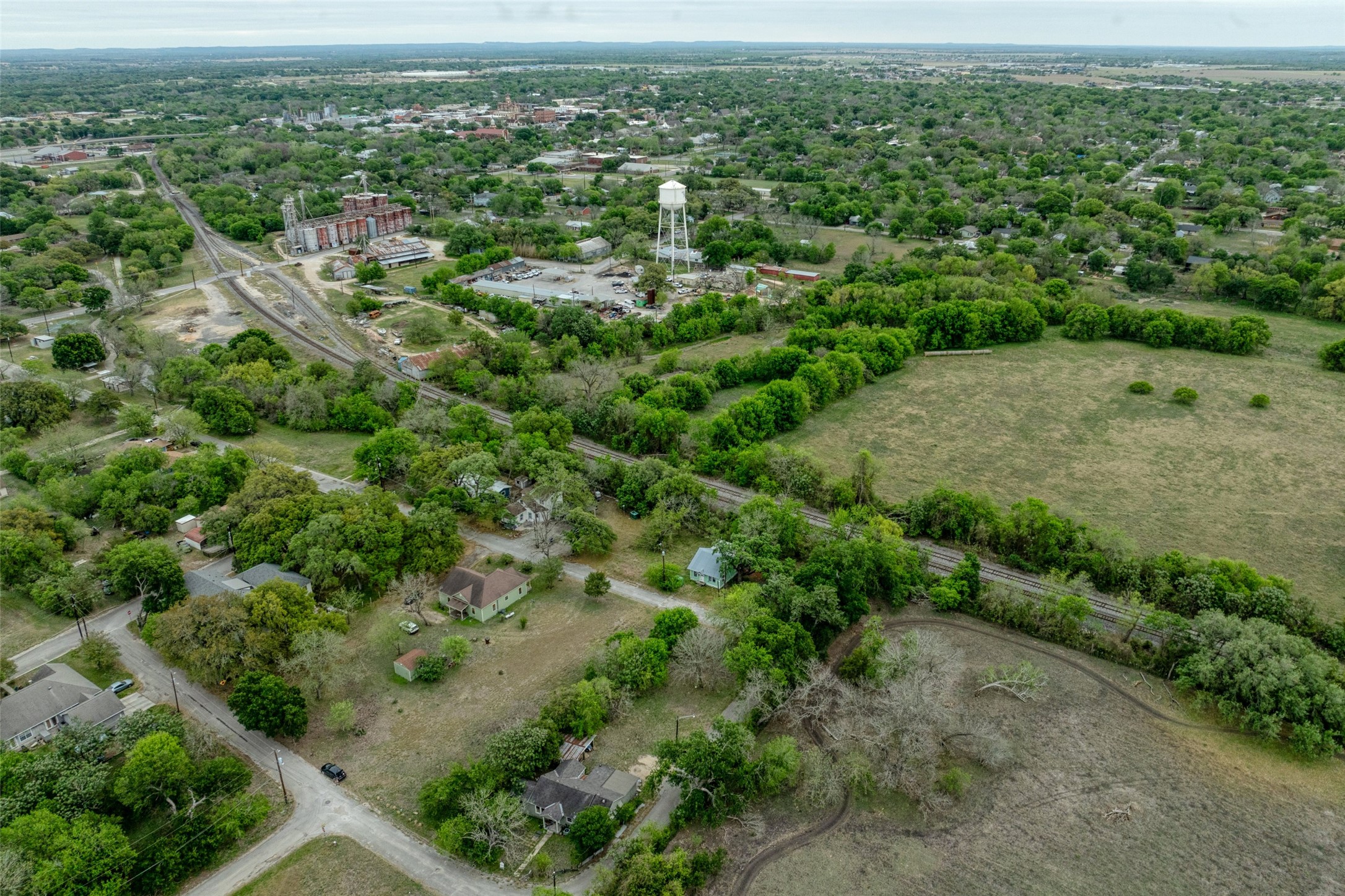 1002 Proctor Street Lockhart, TX 78644 - Photo 4 of 8 an aerial view of residential houses with outdoor space and trees