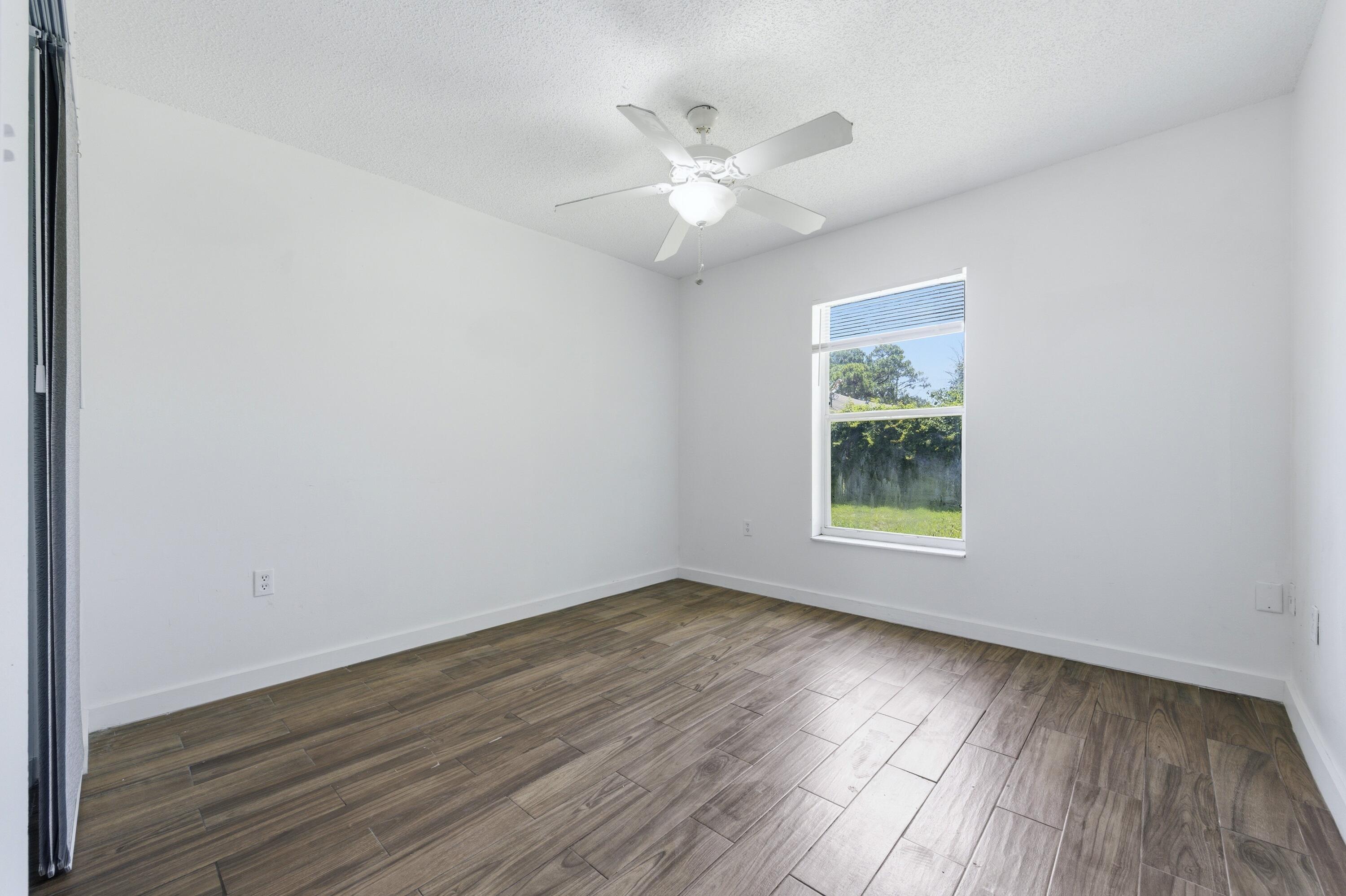 6088 Heather Street Jupiter, FL 33458 - Photo 14 of 18 an empty room with wooden floor and windows