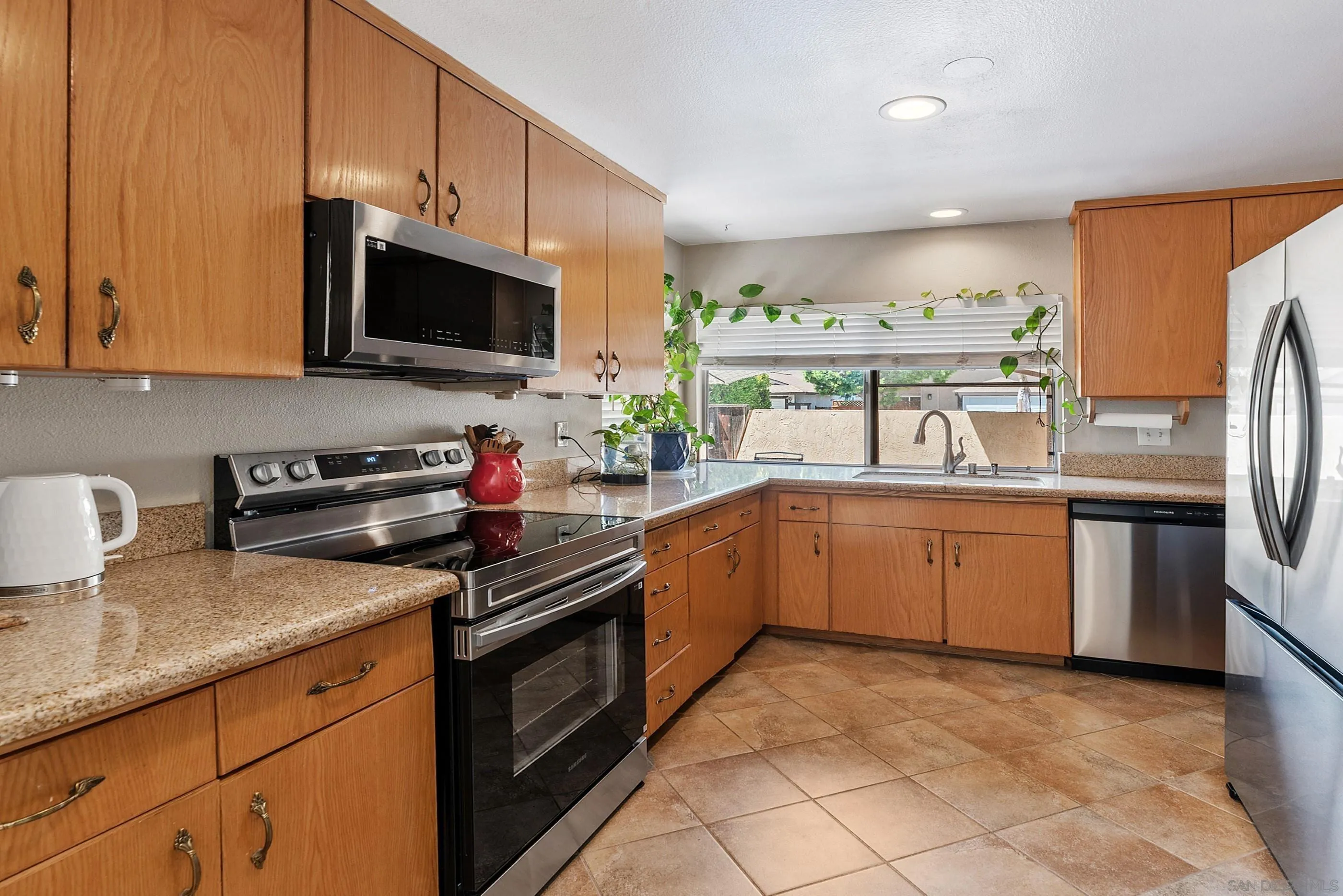 2268 Village Road Escondido, CA 92026 - Photo 12 of 43 a kitchen with stainless steel appliances granite countertop a sink dishwasher stove top oven and refrigerator with wooden floor