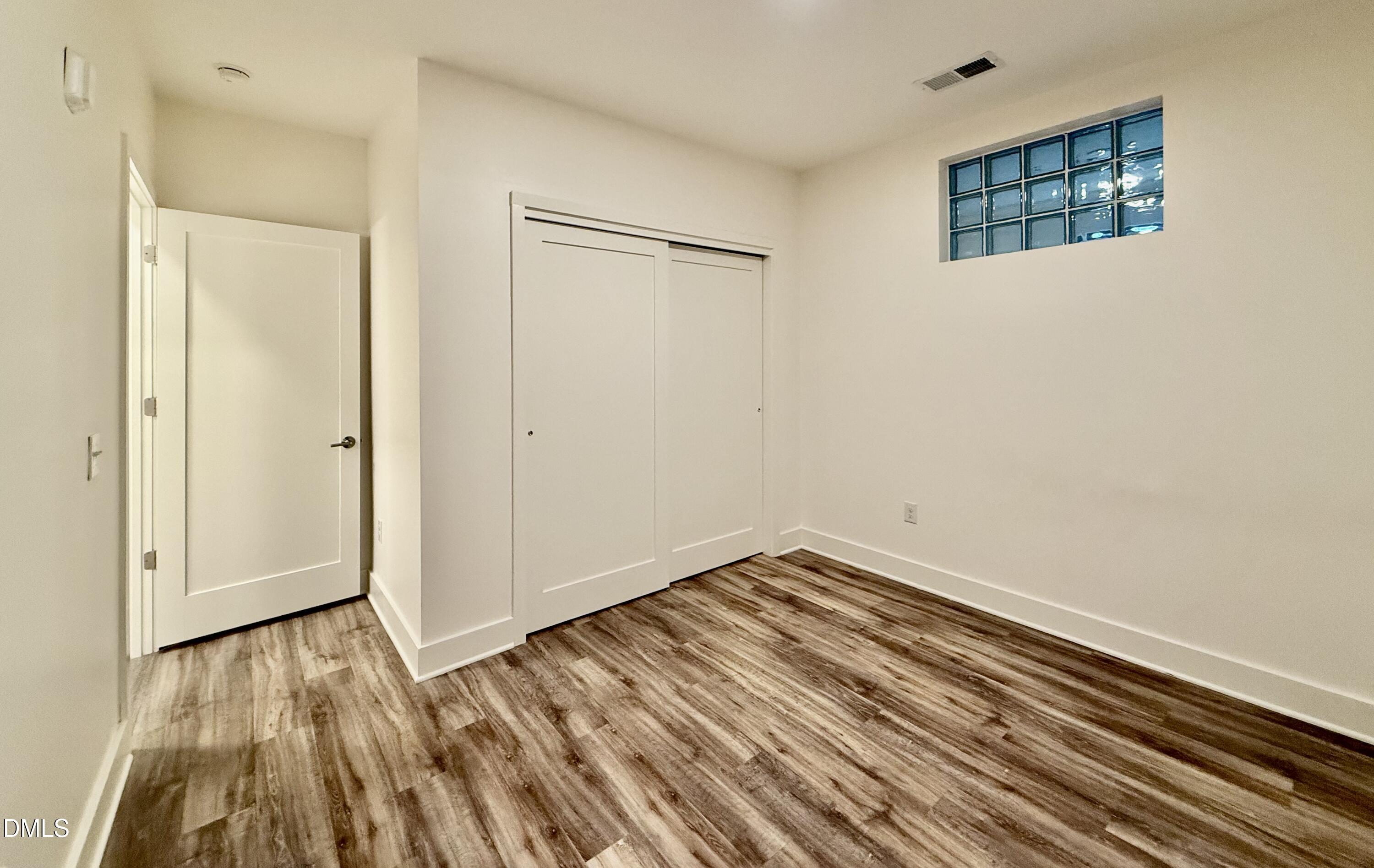 610 Trent Drive, Unit 403 Durham, NC 27705 - Photo 14 of 51 a view of an empty room with wooden floor and a window
