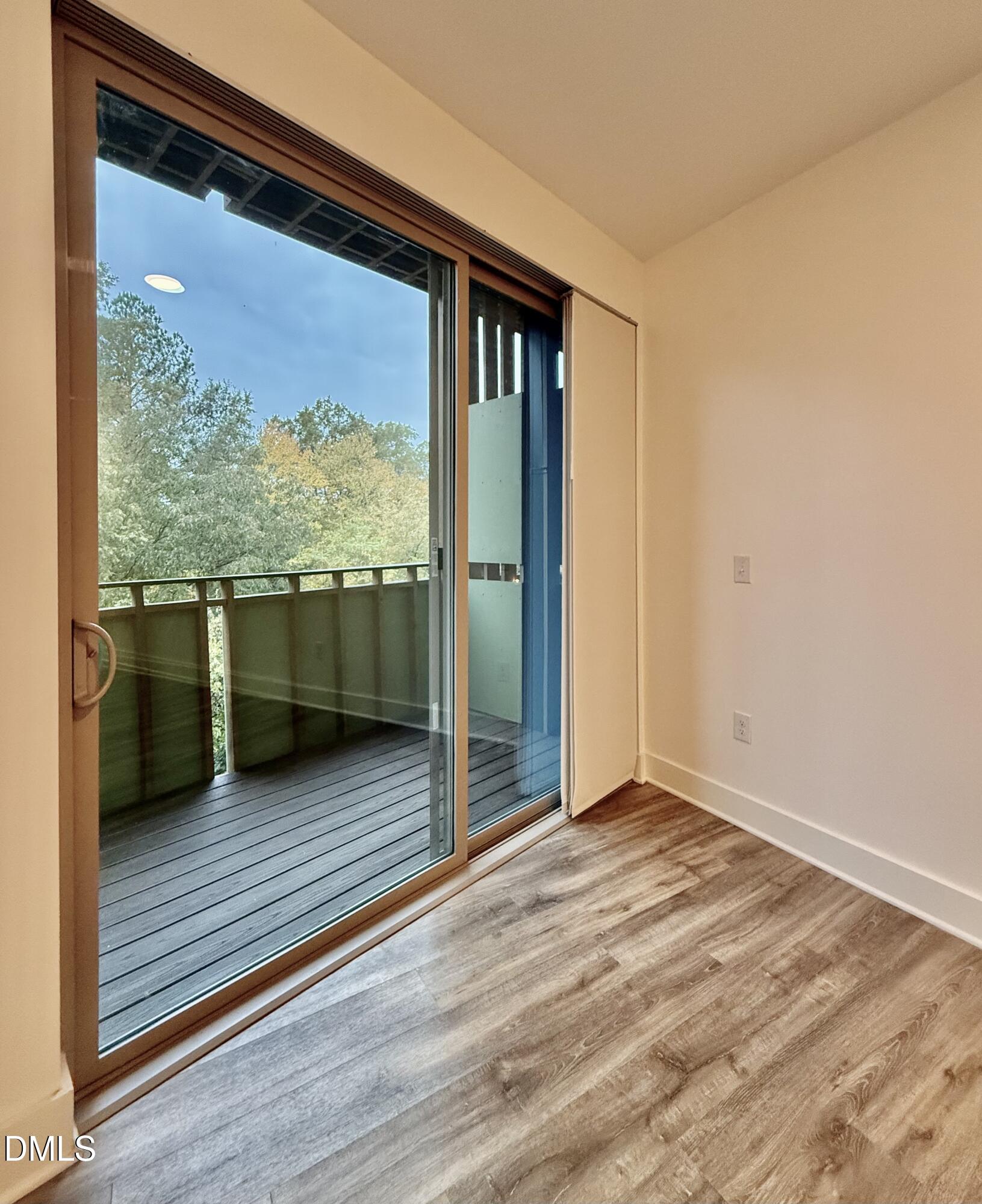 610 Trent Drive, Unit 403 Durham, NC 27705 - Photo 27 of 51 a view of an empty room with wooden floor and a window