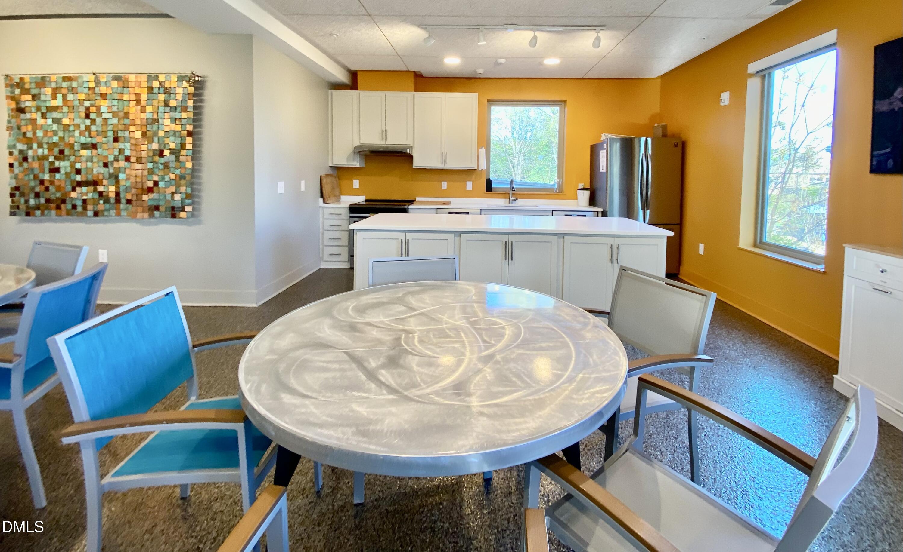 610 Trent Drive, Unit 403 Durham, NC 27705 - Photo 32 of 51 a view of a kitchen with kitchen island a large window a sink and a dining table