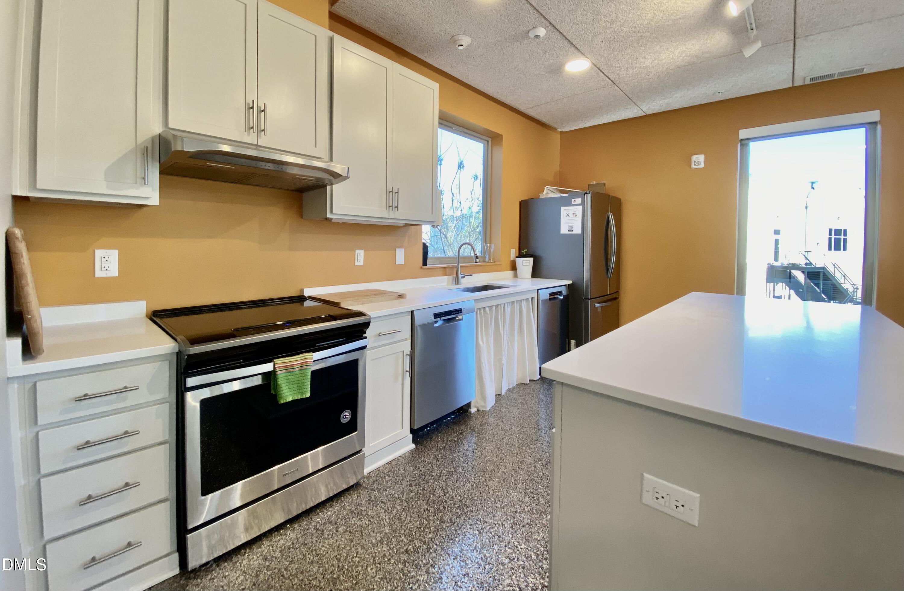 610 Trent Drive, Unit 403 Durham, NC 27705 - Photo 33 of 51 a kitchen with stainless steel appliances a stove a sink cabinets and a refrigerator