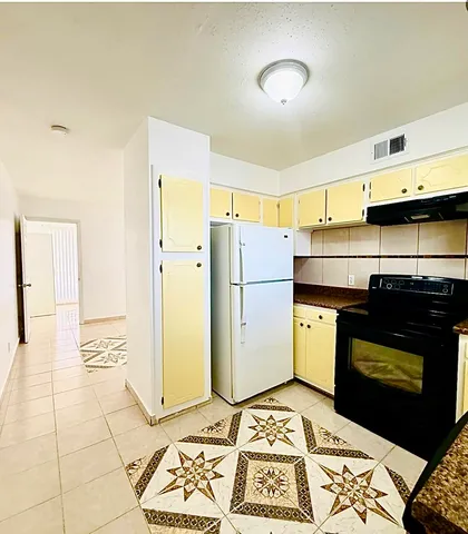 a kitchen with a refrigerator and a stove