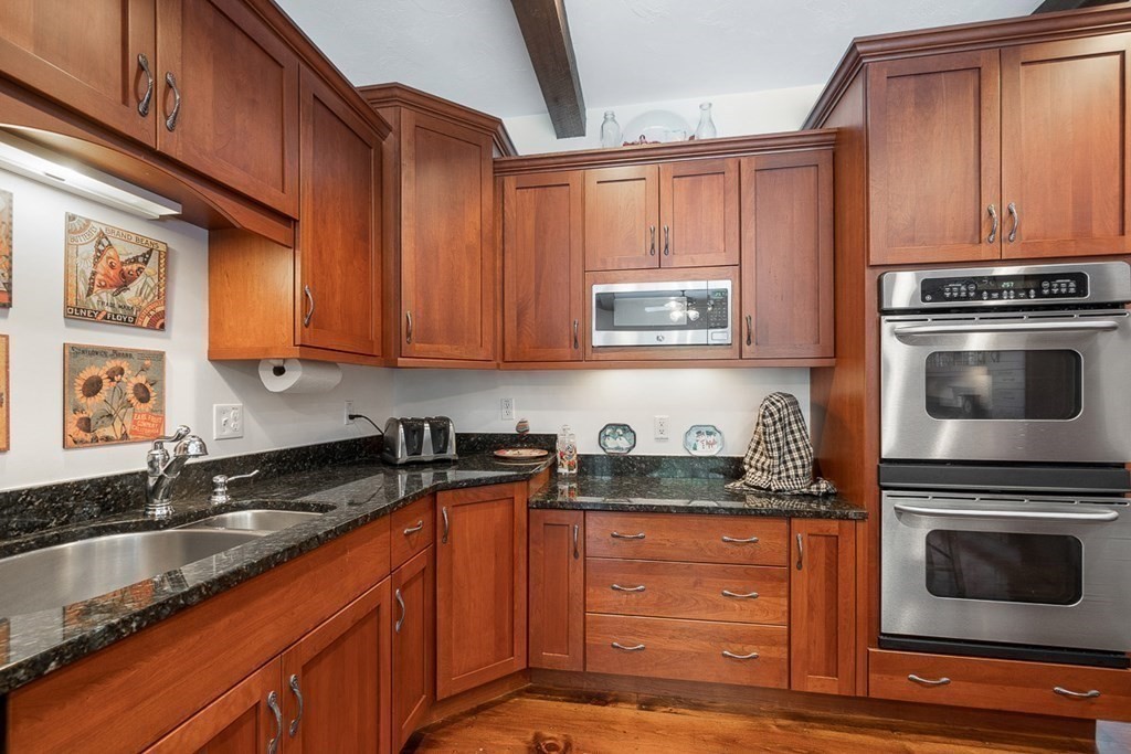 281 Taylor Road Stow, MA 01775 - Photo 14 of 42 a kitchen with stainless steel appliances granite countertop a sink stove and microwave