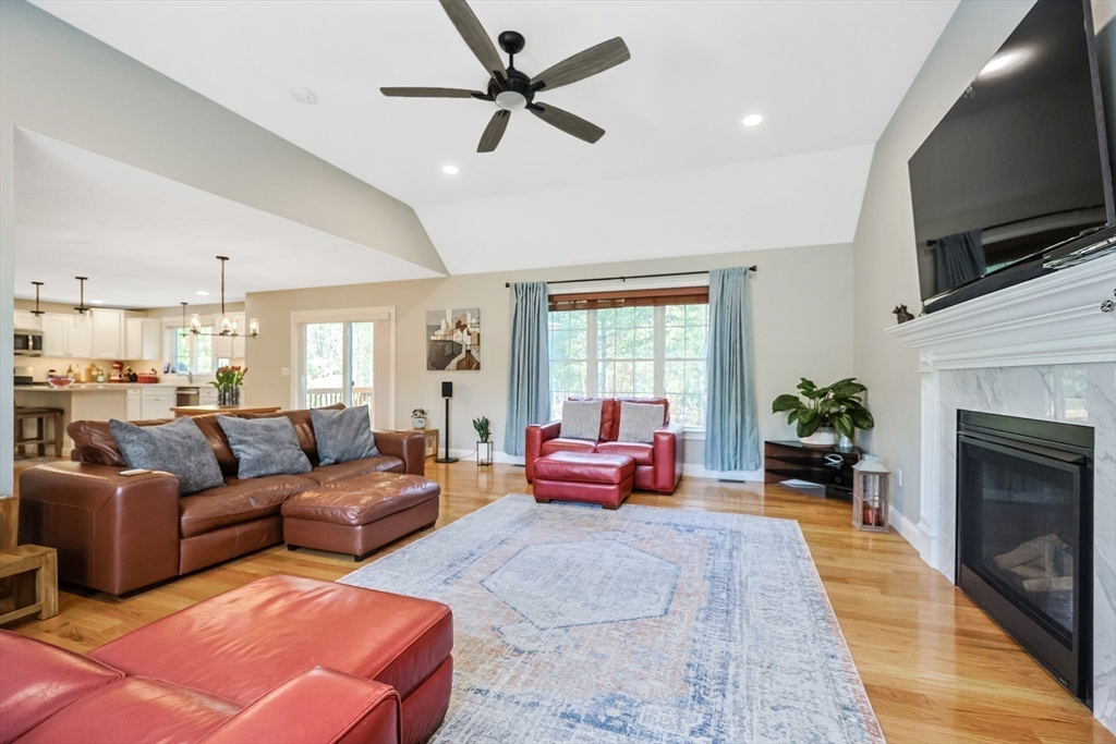 27 Paddock Circle Middleboro, MA 02346 - Photo 15 of 35 a living room with furniture a fireplace a flat screen tv and potted plant