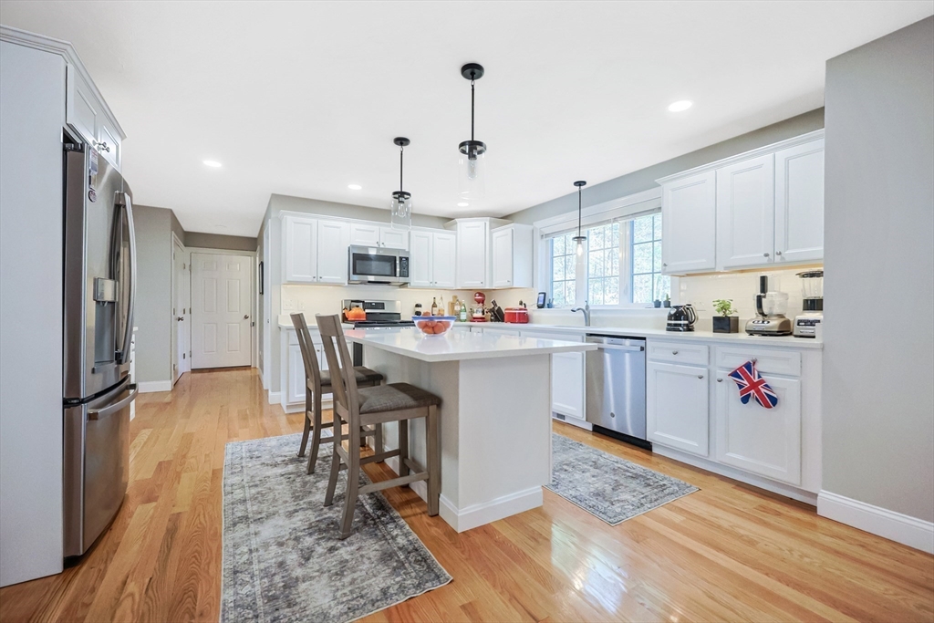 27 Paddock Circle Middleboro, MA 02346 - Photo 9 of 35 a kitchen with stainless steel appliances granite countertop a sink dishwasher a refrigerator and a dining table with wooden floor