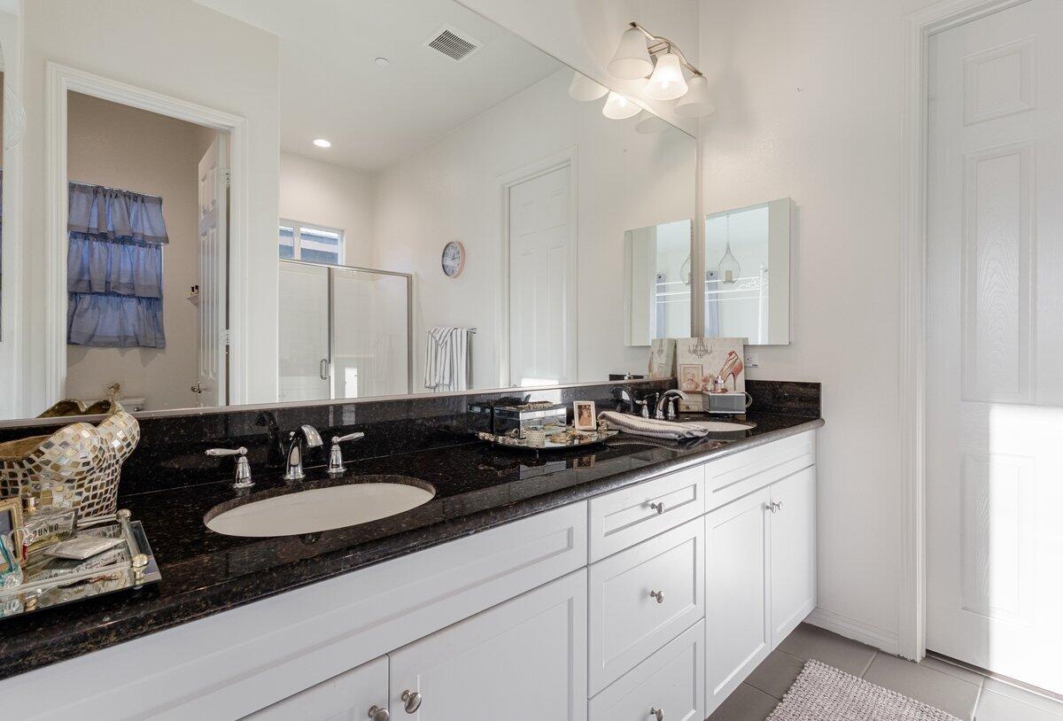 44027 Triolo Way Indio, CA 92203 - Photo 9 of 17 a bathroom with double vanity sinks a vanity and a mirror