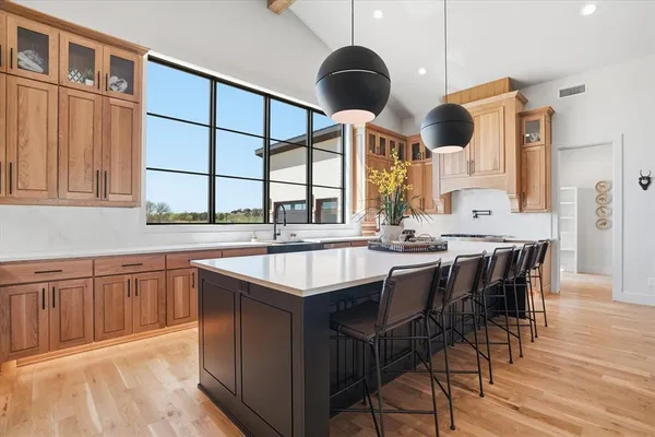 a kitchen with stainless steel appliances kitchen island granite countertop a table chairs in it and wooden floors