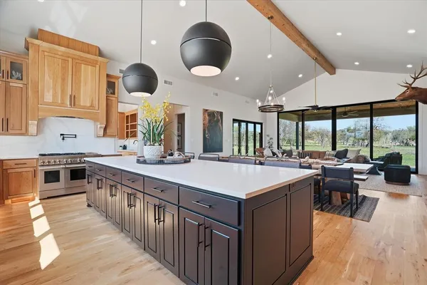 a kitchen with lots of counter space a sink appliances and a large window