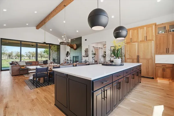 a kitchen with kitchen island a large counter space a sink appliances and a large window