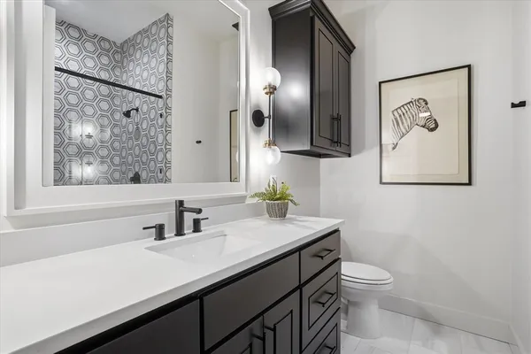 a bathroom with a toilet sink and mirror