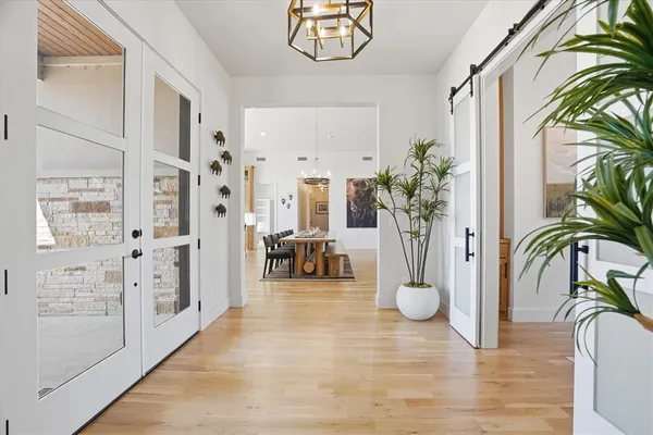 a view of a hallway with furniture and a chandelier