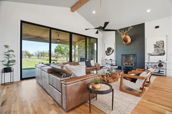 a living room with fireplace furniture and a large window