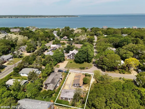 an aerial view of house with yard and ocean view