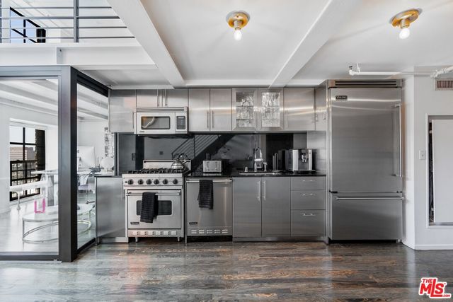 a kitchen with stainless steel appliances granite countertop a refrigerator and a stove