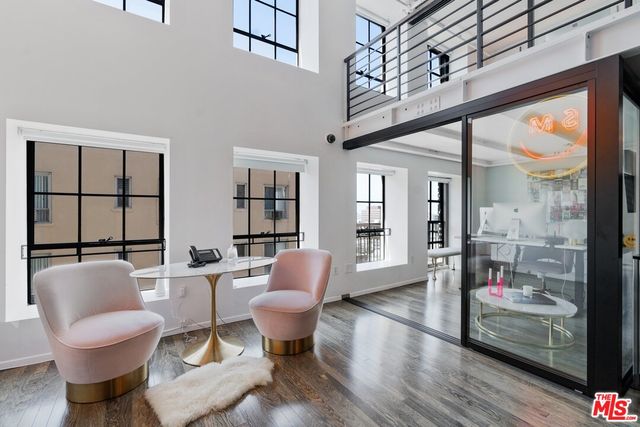 a living room with furniture a flat screen tv and a floor to ceiling window