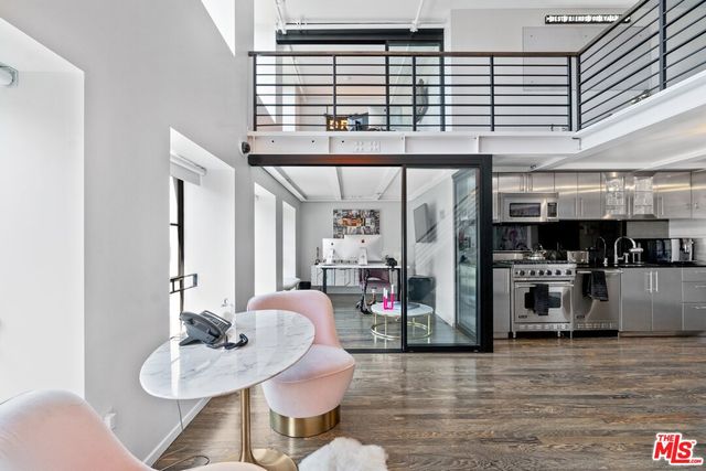 a living room with furniture kitchen view and a large window