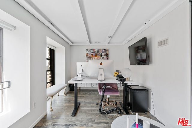 a living room with furniture a flat screen tv and kitchen view