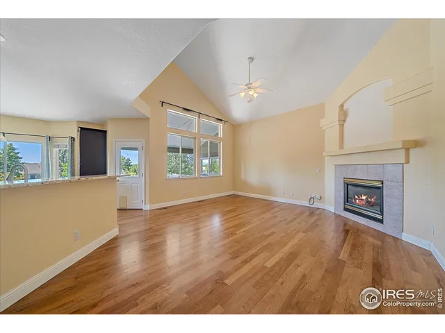a view of empty room with wooden floor and fireplace