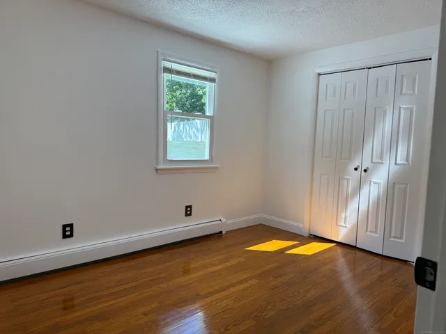 an empty room with a window and ceiling fan