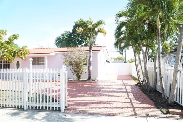 a front view of a house with a tree