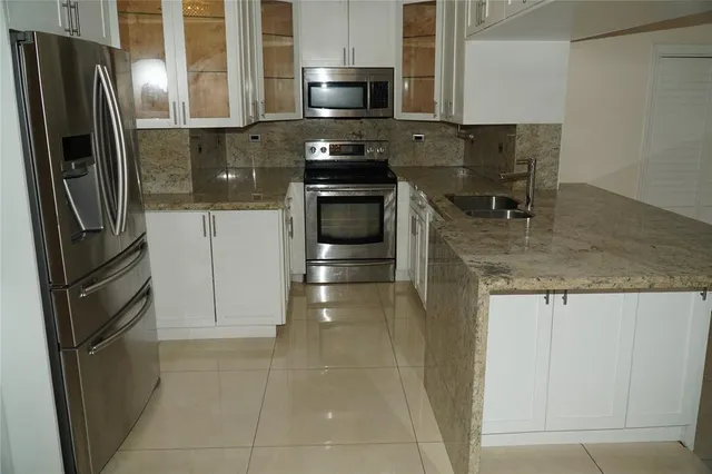 a kitchen with stainless steel appliances granite countertop a refrigerator and a stove