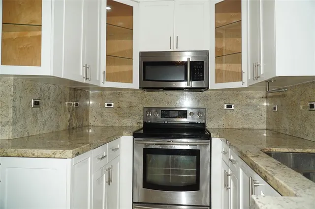 a kitchen with stainless steel appliances granite countertop a stove and a microwave