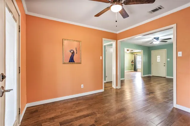 a view of a hallway with wooden floor and a ceiling fan