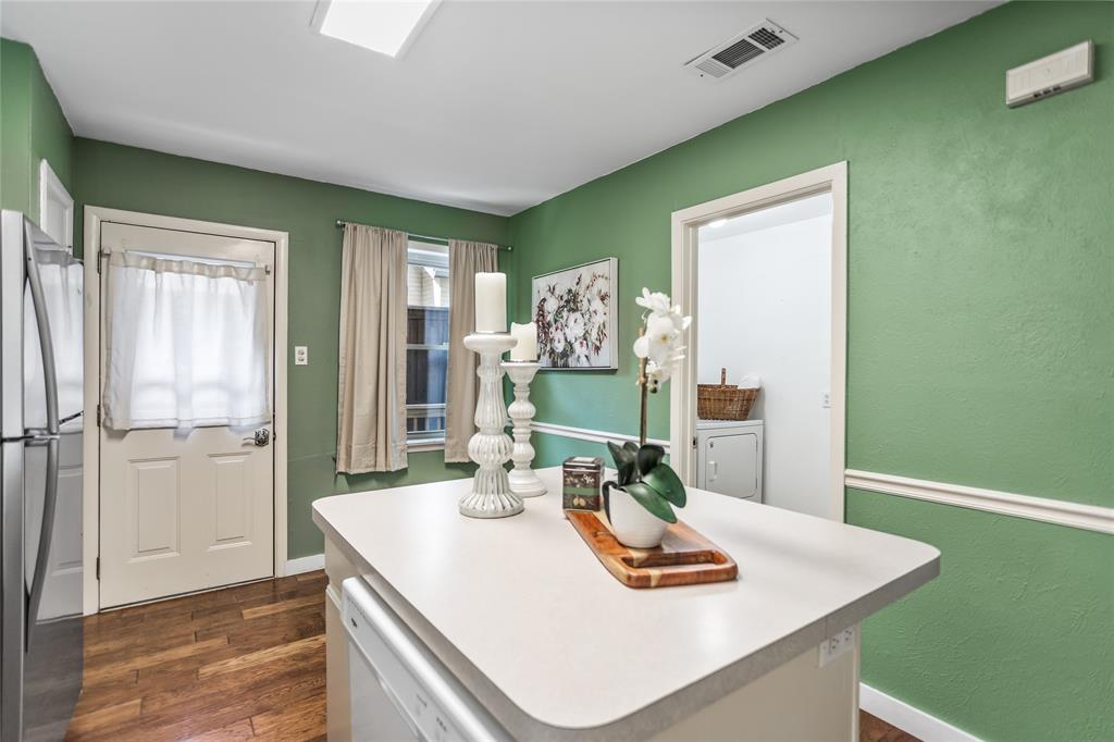 435 Hanbee Street Richardson, TX 75080 - Photo 16 of 36 Kitchen with freestanding refrigerator, dishwasher, dark wood-type flooring, a center island, and light countertops