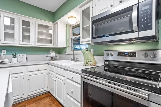a kitchen with stainless steel appliances granite countertop a sink and a microwave