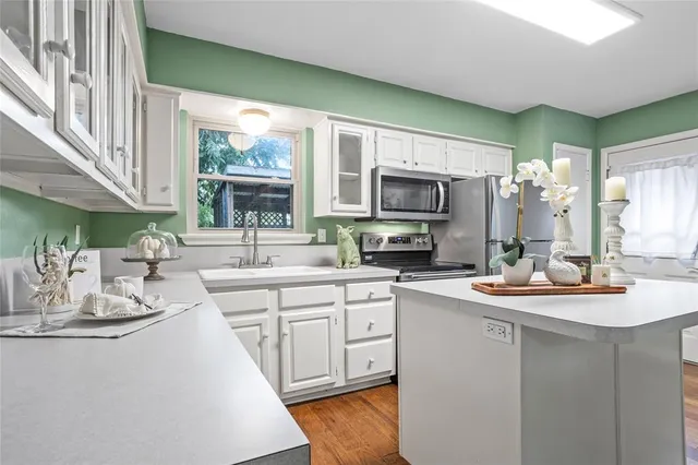 a kitchen with sink a microwave and cabinets