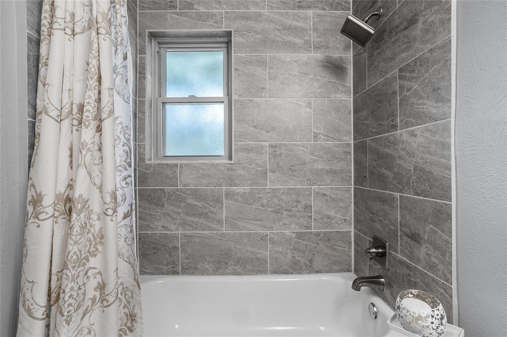 435 Hanbee Street Richardson, TX 75080 - Photo 26 of 36 Bathroom featuring shower / bath combo with updated tile surround and bath faucets.