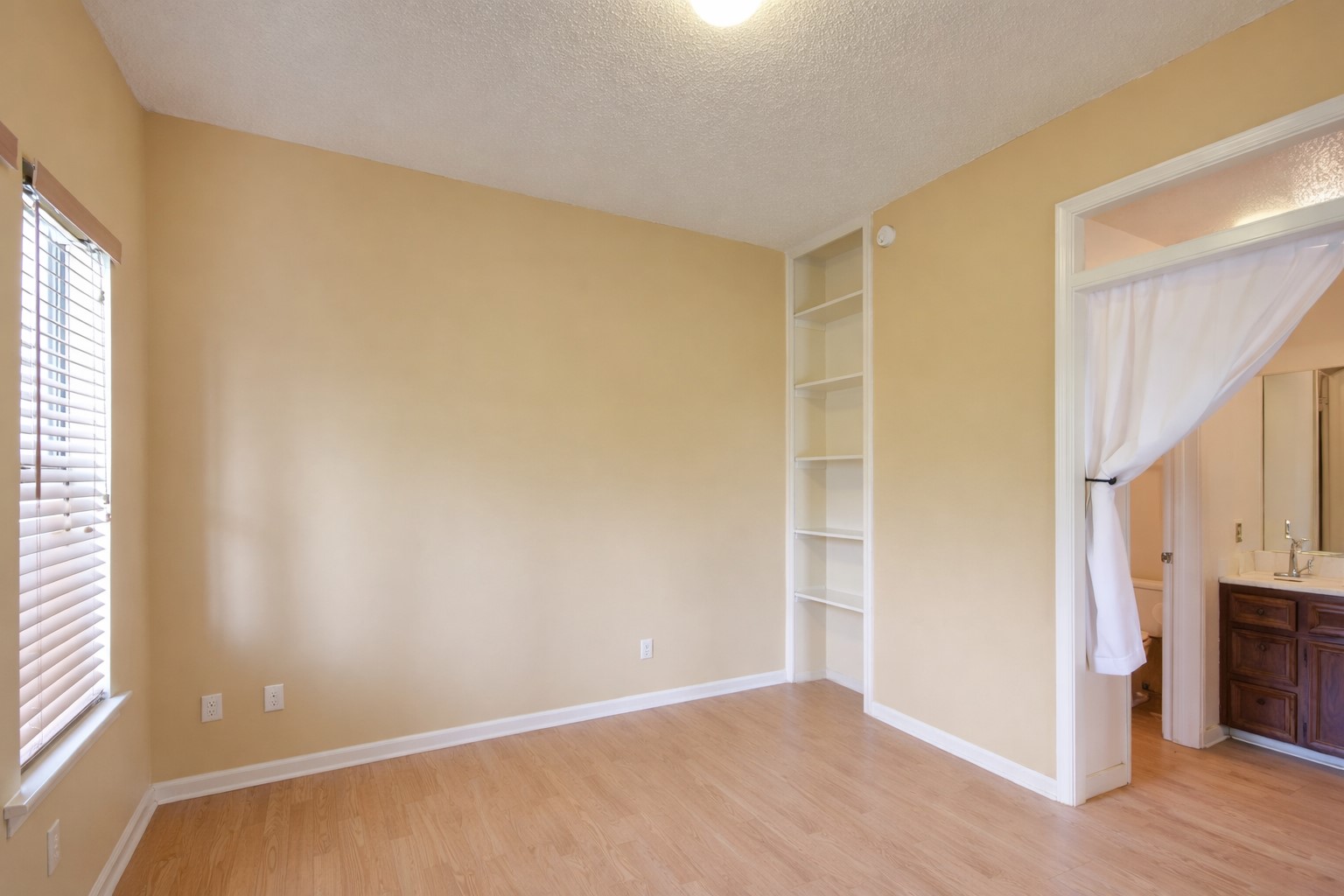 3115 Tom Green Street, Unit 404 Austin, TX 78705 - Photo 9 of 19 Room with light wood-finish flooring, a window with blinds, and built-in shelving