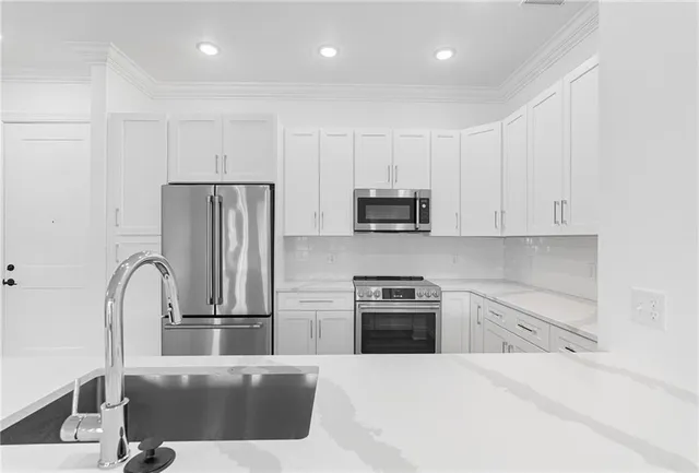 a large kitchen with stainless steel appliances granite countertop a large counter top and a wooden floors