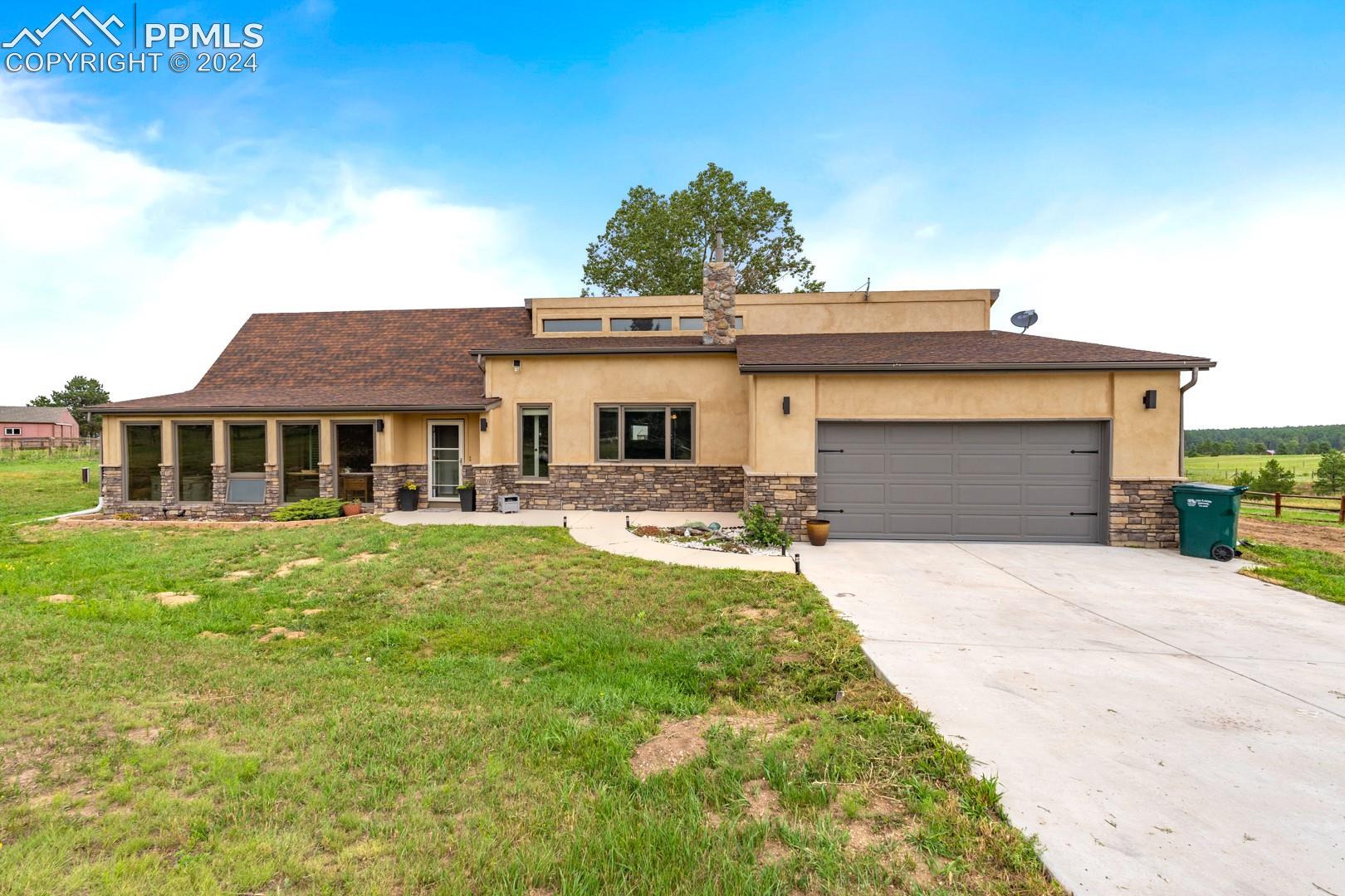 3880 Walker Road Colorado Springs, CO 80908 - Photo 1 of 3 View of front of property featuring a front lawn and a garage