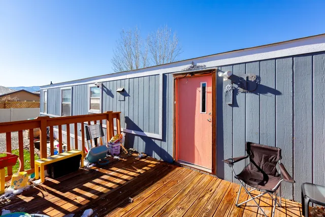 a balcony with wooden floor table and chairs