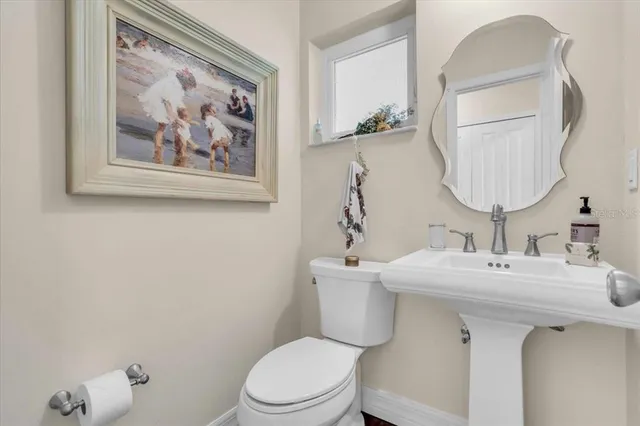 a bathroom with a toilet a sink and mirror