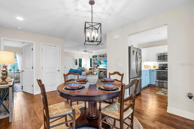 a view of a dining room and livingroom with furniture wooden floor a chandelier