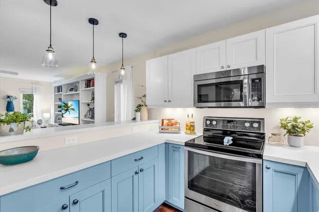 a kitchen with stainless steel appliances a stove a microwave a sink and cabinets