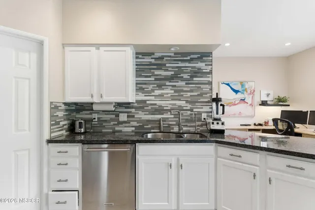 a kitchen with granite countertop white cabinets and white appliances