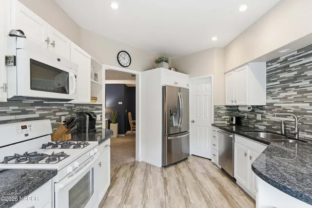 a kitchen with stainless steel appliances granite countertop a stove refrigerator and microwave