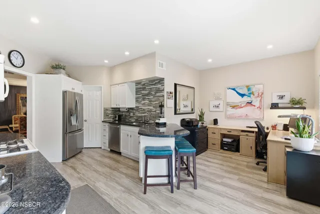 a kitchen with a refrigerator and a stove top oven