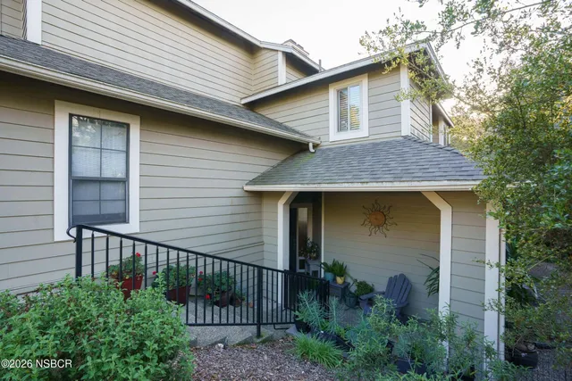 a view of a small house with wooden fence