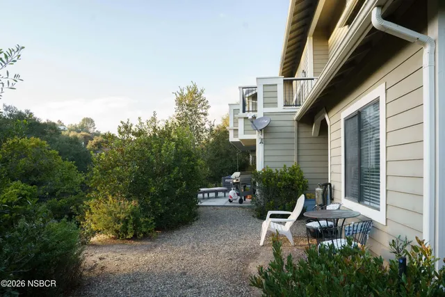 a view of a chair and table in backyard of the house