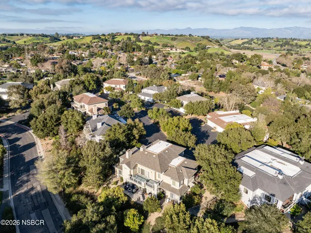 an aerial view of a residential houses with yard