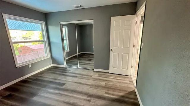 an empty room with windows and closet