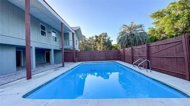 a view of a backyard and basketball court