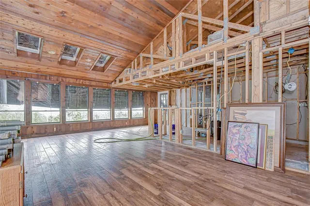 a view of a livingroom with wooden floor and a large window