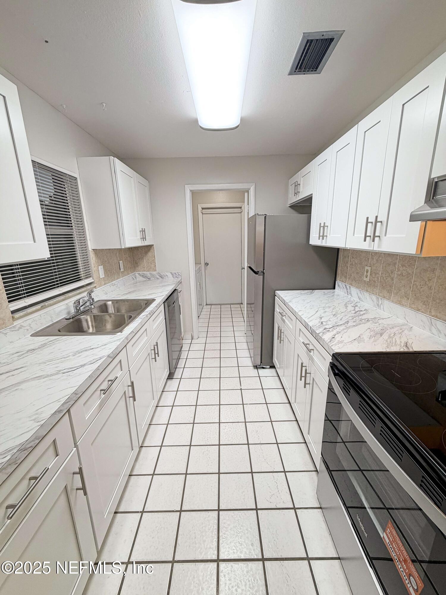 283 Almansa Road St. Augustine, FL 32086 - Photo 5 of 16 a kitchen with a sink a stove and cabinets